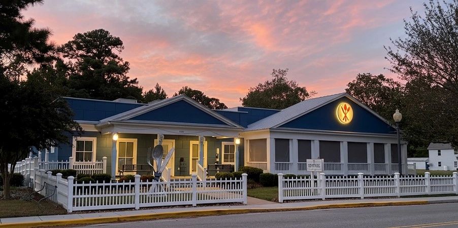 Modern commercial building with blue roof at golden hour