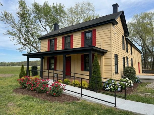 Charming two-story farmhouse with cream and red siding